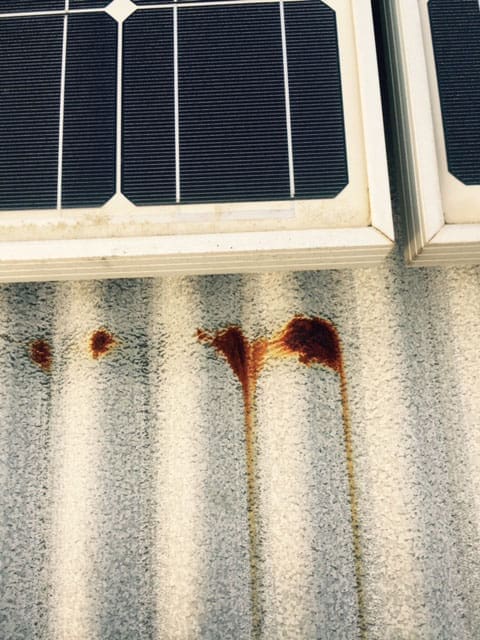 Close up view of corrosion on a metal roof sheet from a solar panel